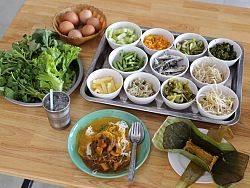 Kanom Jeen is a rice noodle dish served with fresh, local vegetables and spicy fish curry. It is delicious!