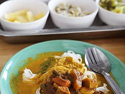Kanom Jeen is a rice noodle dish served with fresh, local vegetables and spicy fish curry. It is delicious!