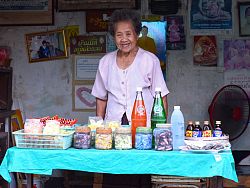 A woman sells drinks and sweets from her house in the old part of Lampang