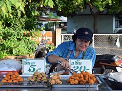 A woman sells fried chicken and sausages