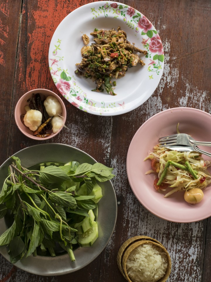 A typical Issan meal consists of young papaya salad, minced duck salad, sticky rice and herby greens.
