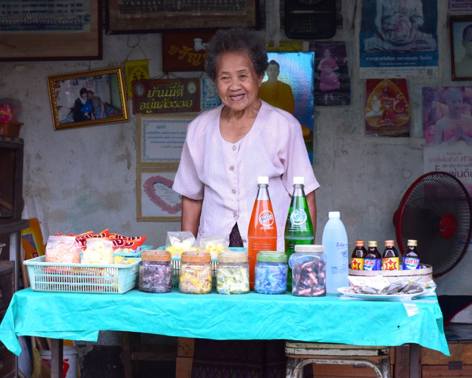 A woman sells drinks and sweets from her house in the old part of Lampang